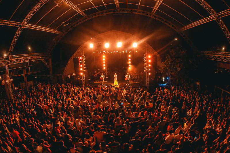 oto do palco do Belvedere Beach Club na Praia Brava durante um show nacional com a pista lotada.